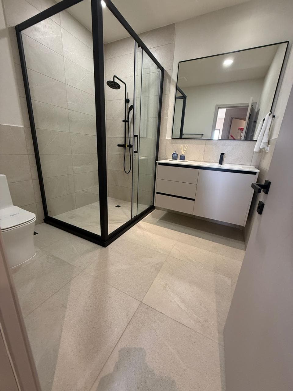 Bathroom vanity with large format stone tile floor and floating cabinet