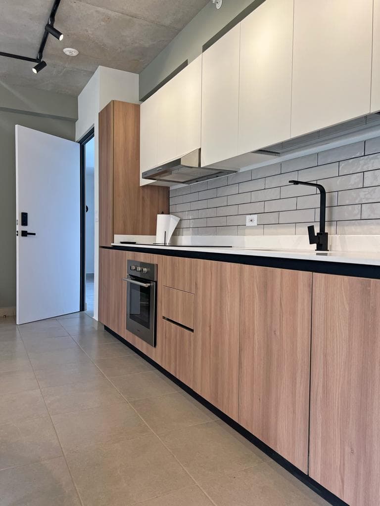 L-shaped kitchen with light wood melamine and white quartz countertop